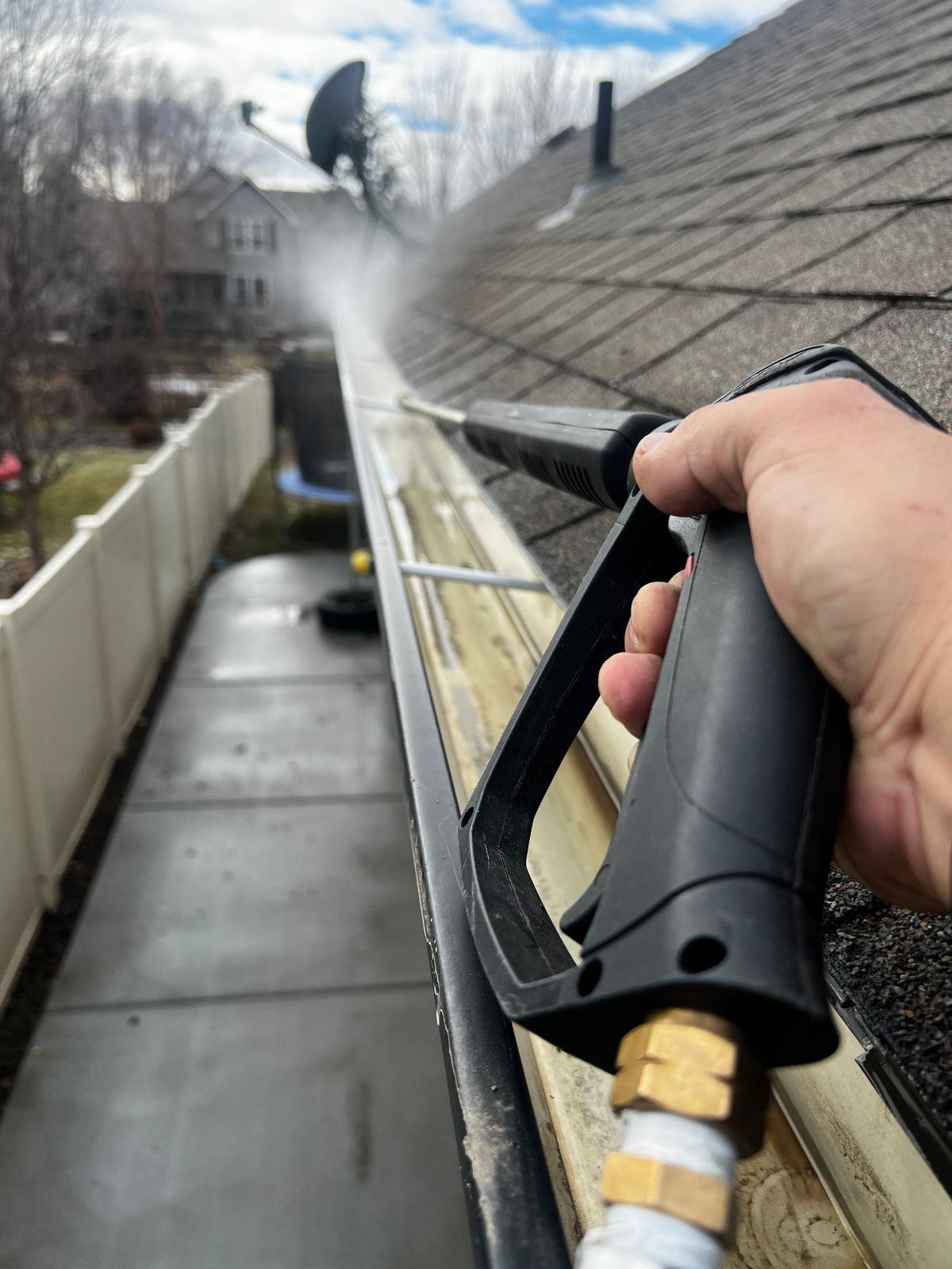 Close-up of gutter cleaning with a pressure washer